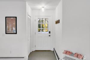 a hallway with white walls and a white door at Northern Nest MDI Lakefront Single-Level, Dual King Bedrooms & Private Dock in Pretty Marsh +54 photos