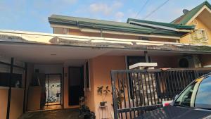 a house with a balcony and a car parked in front at Casa Minsorado in General Trias