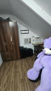 a large purple teddy bear sitting on the floor of a room at Casa Minsorado in General Trias