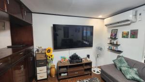 a living room with a couch and a flat screen tv at Casa Minsorado in General Trias