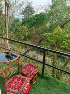 a balcony with a table and chairs on the grass at Jungle Nirvana Retreat in Meghauli