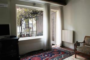 a room with a window with a chair and a rug at Sarai Apartments in Venice