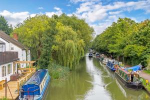 un fiume con barche parcheggiate sul lato di Linslade Apartment - for Groups and Contractors a Leighton Buzzard