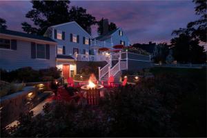 a backyard with a fire table and chairs at night at Captain Swift Inn in Camden