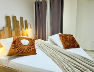 a bedroom with two beds with pillows on them at Appartement spacieux La Vanille 2 in Ducos