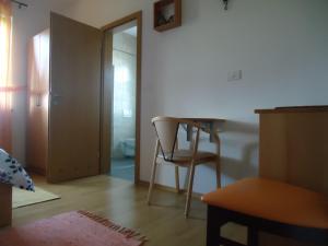 Habitación con silla, mesa y puerta en Lipizzaner Lodge Guest House, en Postojna