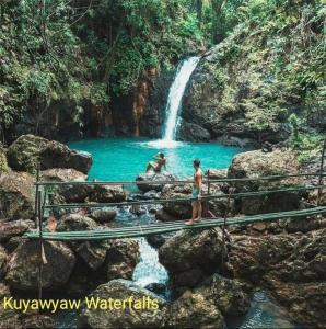 two people standing on a bridge in front of a waterfall at El Nido Bayview in El Nido