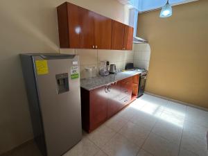 a kitchen with a refrigerator and wooden cabinets at Oasis House 2 in Tocumen +8 photos