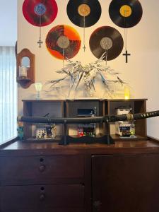 a room with a wooden cabinet with records on the wall at 221B Baker in Ga Phú Văn