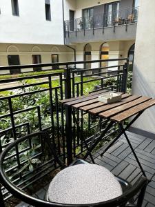 a wooden table and a chair on a balcony at SWU Magazine Rooms in Budapest