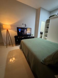 a bedroom with a bed and a flat screen tv at Casa Belchior in Sobral