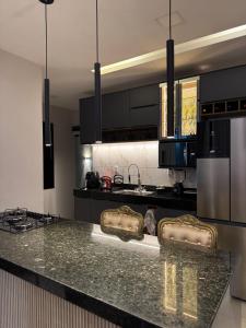 a kitchen with black cabinets and a granite counter top at Casa Belchior in Sobral +10 photos