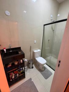 a bathroom with a toilet and a sink and a shower at Casa Belchior in Sobral