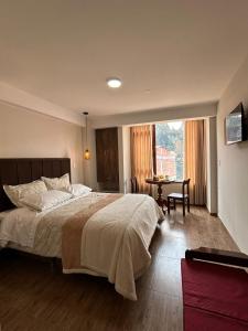 a bedroom with a large bed and a table at Juan Placido Hospedaje in Cusco