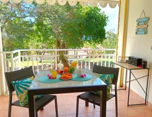 a table with fruit on it on a balcony at Le Tropical in Sainte-Anne