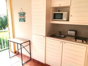a kitchen with a sink and a microwave at Le Tropical in Sainte-Anne +17 photos