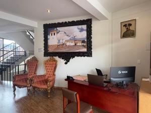 an office with a desk and a computer on a wall at Juan Placido Hospedaje in Cusco