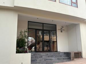 a white building with a glass door and stairs at Juan Placido Hospedaje in Cusco