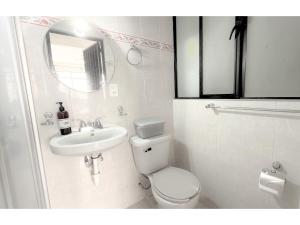 a white bathroom with a toilet and a sink at HOMSTY Escondite chido de Texmelucan in San Martín Texmelucan de Labastida