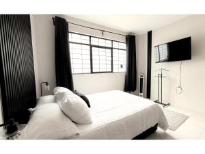 a bedroom with a white bed and a window at HOMSTY Escondite chido de Texmelucan in San Martín Texmelucan de Labastida