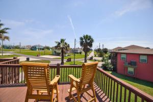 two wooden chairs sitting on a deck at Caribbean Palm Retreat 3BR Near Crystal Beach Fireplace in Bolivar Peninsula