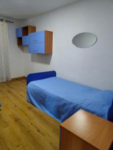 a bedroom with a blue bed and a wooden floor at Cascina Danila in Narzole