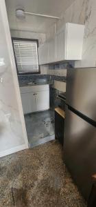 a kitchen with white cabinets and a stainless steel refrigerator at E & E Motel in Myrtle Beach