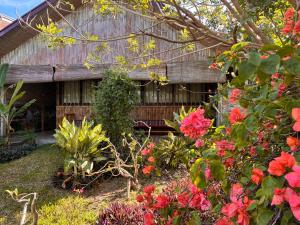 a garden with flowers in front of a building at The Lazy Tiki in Buenavista