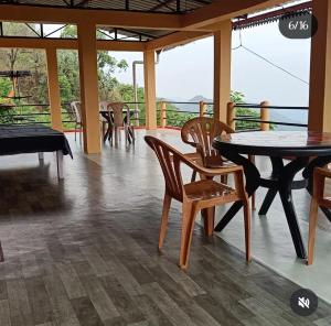 a dining room with tables and chairs and a balcony at Harender nayal homestay in Bhīm Tāl
