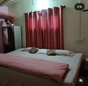 a bedroom with a bed with a red curtain at Harender nayal homestay in Bhīm Tāl +3 photos
