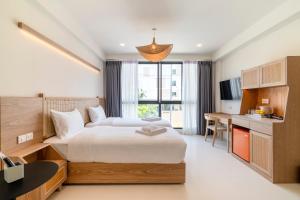 a hotel room with a bed and a desk at Rim Apartment Pattaya in Pattaya South