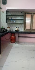 a kitchen with a counter and a red pot under it at JPR Cottage in Erode +5 photos