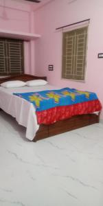 a bedroom with a bed with a blue comforter at JPR Cottage in Erode