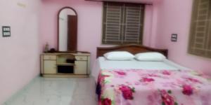 a bedroom with a bed and a mirror at JPR Cottage in Erode