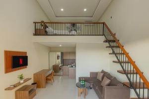 a living room with a staircase and a couch at DC 08 Residence in Dalung