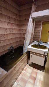 a bathroom with a sink and a bath tub at La maison de papy près de la plage in Barbâtre +8 photos