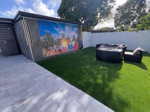 a backyard with a large mural on the fence at Fun n Chic house with pool in Miami in Golden Glades