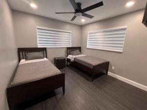 a room with two beds and a ceiling fan at Fun n Chic house with pool in Miami in Golden Glades +31 photos
