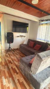 a living room with a couch and a tv at Quinta Villanueva in Ibagué