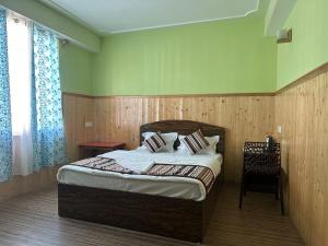 a bedroom with a bed and a chair in it at Hotel Sunrise in Lachen