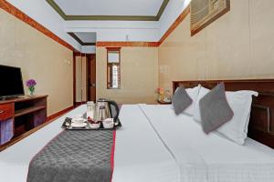 a hotel room with a bed with a tray on it at Hotel O Sasti Inn in Pondicherry