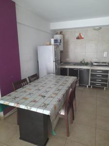 a kitchen with a table with chairs and a refrigerator at Mdp in Mar del Plata