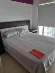 a large white bed with a red towel on it at Mdp in Mar del Plata