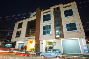 a blue car parked in front of a building at Hotel CROWN PLAZA SK in Rudrapur