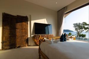 a bedroom with a large bed with a large window at Villa Lotus in Ko Phangan