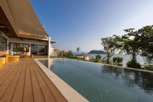 a swimming pool next to a house with the water at Villa Lotus in Ko Phangan