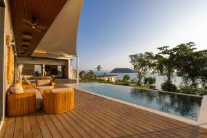 a house with a wooden deck with a swimming pool at Villa Lotus in Ko Phangan