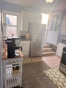 a kitchen with white cabinets and a white refrigerator at Ocean View Cozy Stay 4 in Hull +3 photos
