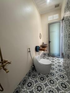 a bathroom with a toilet and a glass door at Khách Sạn Trung Loan in Ninh Hải