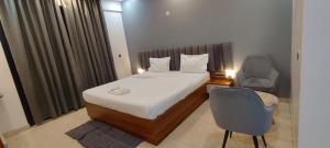 a hotel room with a bed and a chair at RrHEAVENSTAY in Nalmatha